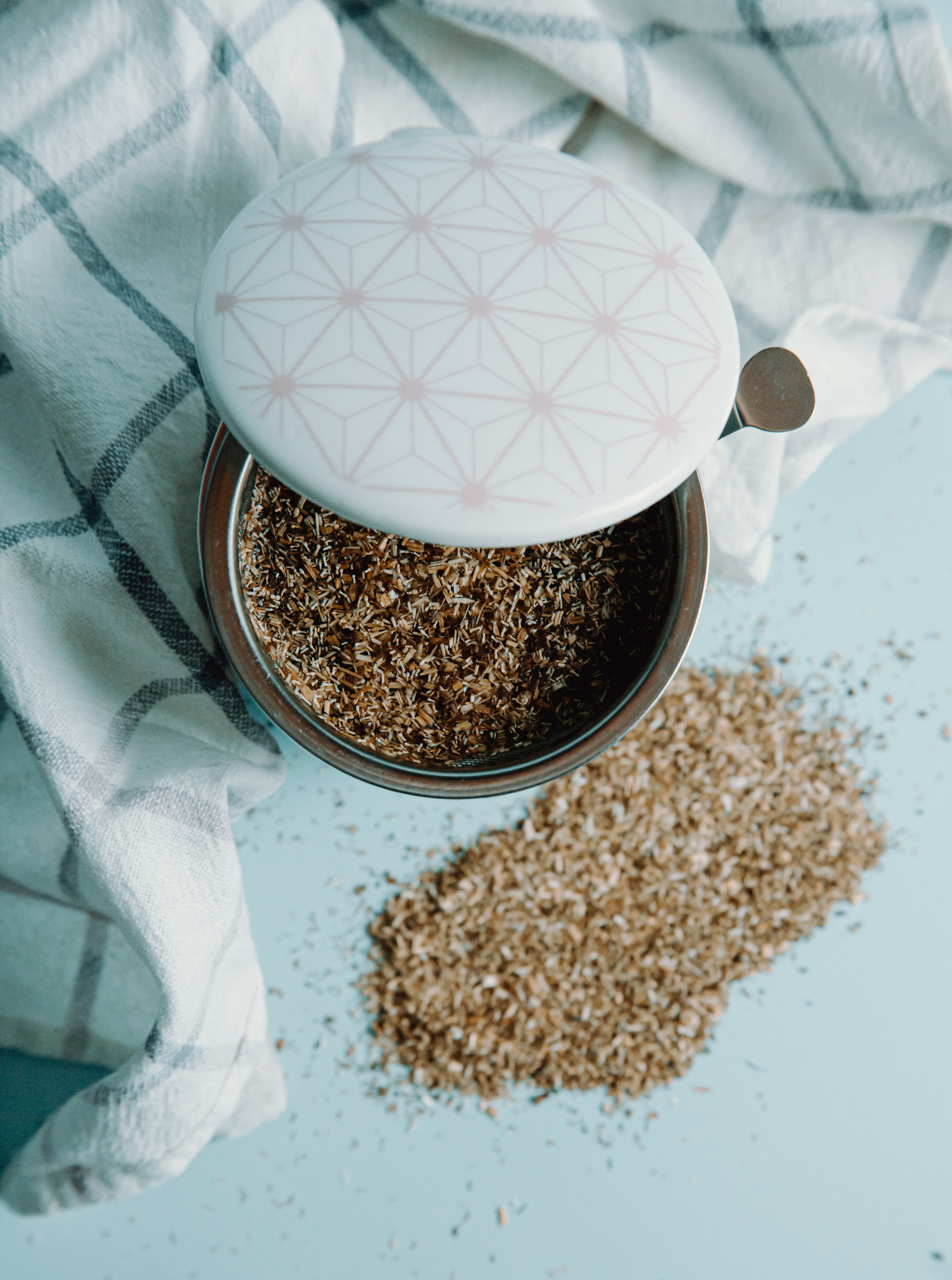 Top view of loose leaf tea steeping in a ceramic mug with tea strainer