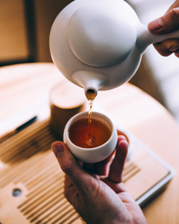 Hand pouring hot tea